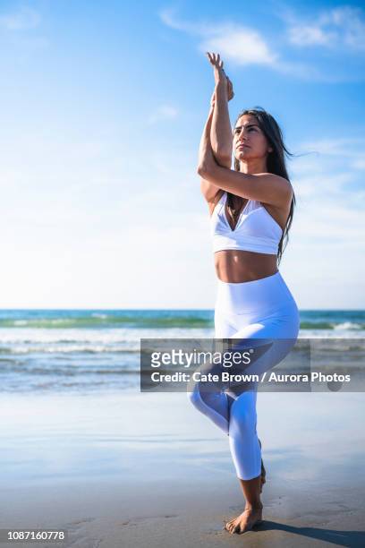 woman doing yoga on beach - tree position stock pictures, royalty-free photos & images