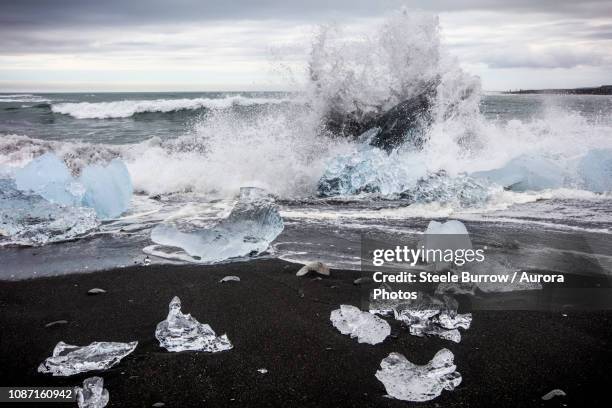 waves splashing at diamond beach, jokulsarlon glacier lagoon, iceland - ice breaking stock pictures, royalty-free photos & images