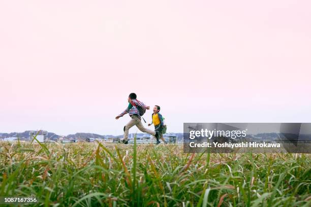 young boys running at riverbank. - 河川敷 ストックフォトと画像