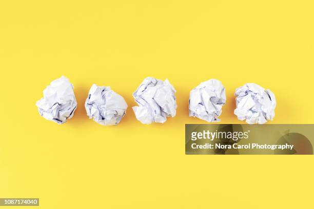 crumpled paper ball on yellow background - paper ball stock pictures, royalty-free photos & images