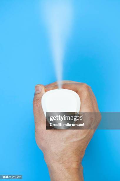 air freshener. hand spraying air freshener - luchtverfrisser stockfoto's en -beelden