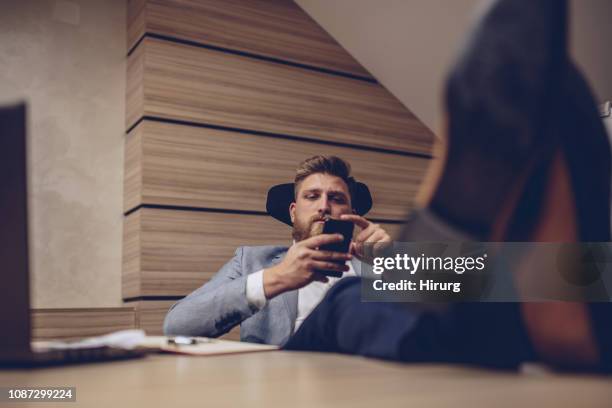 man texting at the office - feet on desk stock pictures, royalty-free photos & images