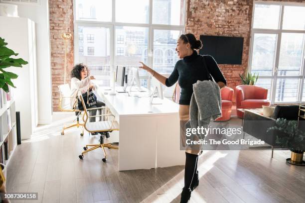 woman waving goodbye to colleague in office - farewell stockfoto's en -beelden