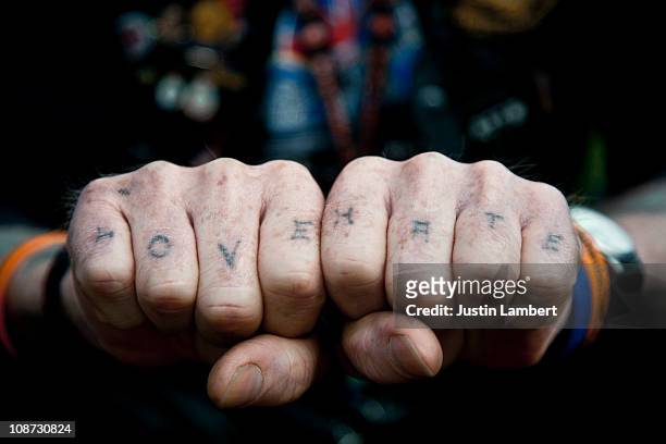 man with love & hate tattooed on his knuckles - knöchel stock-fotos und bilder