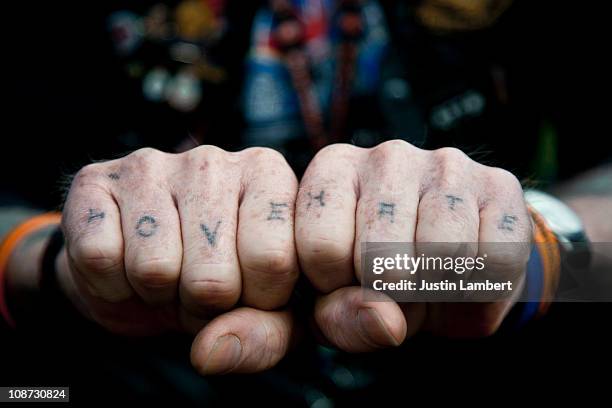 man with love & hate tattooed on his knuckles - knuckle tattoo foto e immagini stock