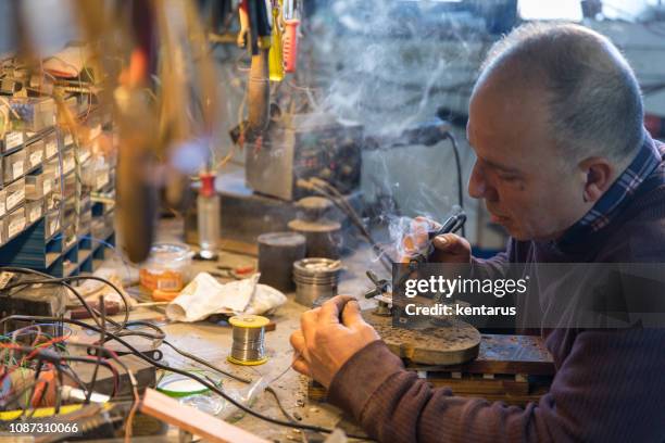 uitvinder man solldering elektronische circuit bord - de systeemkaart van de computer - reparatie - uitvinder stockfoto's en -beelden