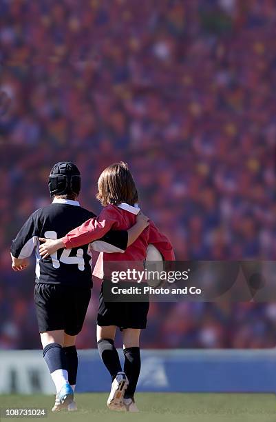 two boys opposing rugby players walking on pitch - kids rugby stock pictures, royalty-free photos & images