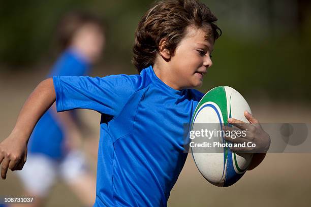 boy rugby player running with ball - kids rugby stock pictures, royalty-free photos & images