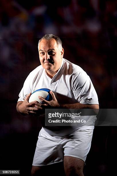 portrait of a man holding a rugby ball - solo un uomo maturo foto e immagini stock