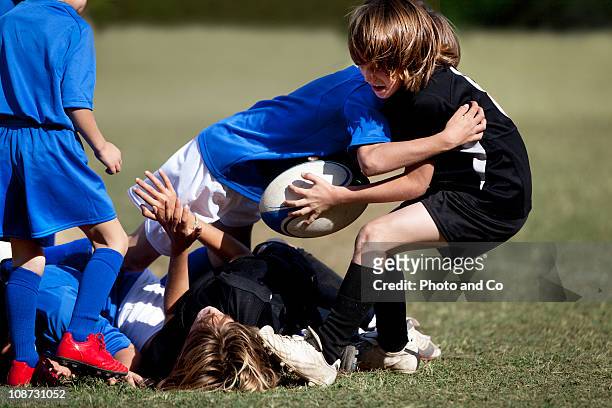 boy running with rugby ball pursued by opponent - kids rugby stock pictures, royalty-free photos & images