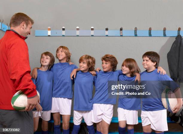 children's rugby coach with players in lock - locker room wall stock pictures, royalty-free photos & images