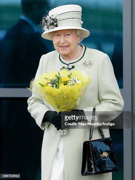 Queen Elizabeth II carries a bouquet of flowers as she leaves Palm Paper mill on February 2, 2011 in Norwich, England. The Queen and the Duke of...