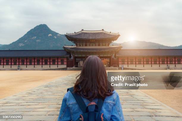 young asian woman traveler with backpack traveling into the gyeongbokgung palace at seoul, south korea. - myeong dong fotografías e imágenes de stock