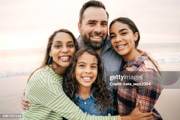 smiling parents with two children - four people stock pictures, royalty-free photos & images
