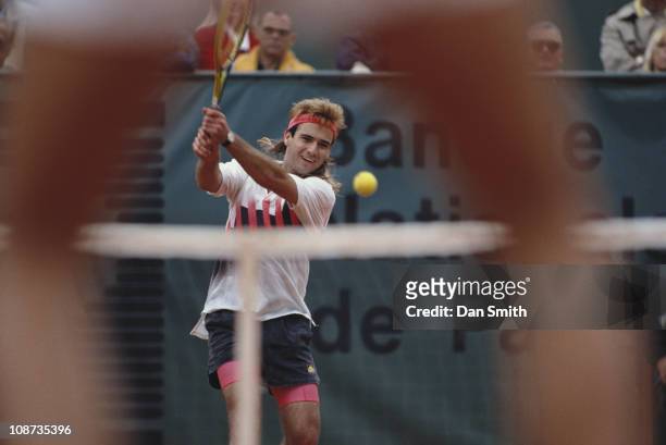 Andre Agassi of the United States makes a double hand return against Andres Gomez during the Men's Singles final match during the French Open Tennis...