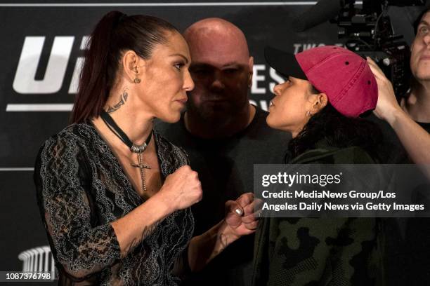 Cris Cyborg, UFC women's featherweight champion, left, and Amanda Nunes, UFC women's bantamweight champion, square off during UFC 232 press...