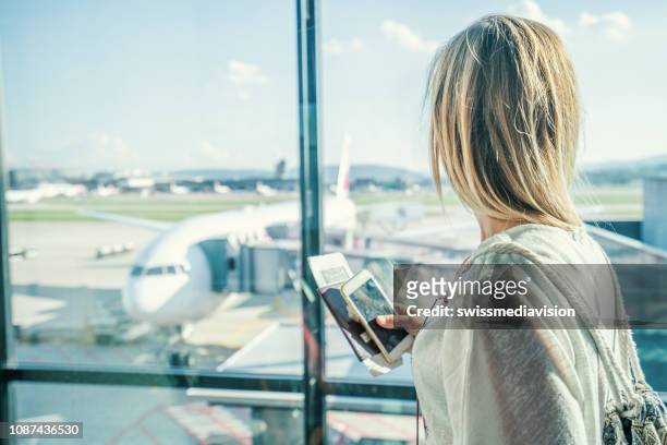 weibchen am flughafen terminal warten für abflug - airport smartphone stock-fotos und bilder