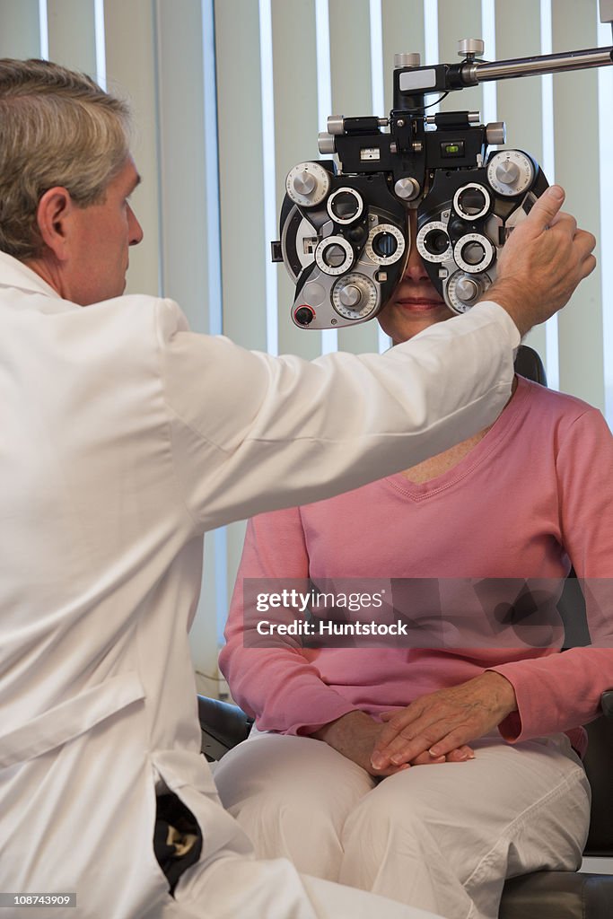 Ophthalmologist examining a woman's eyes with a phoropter