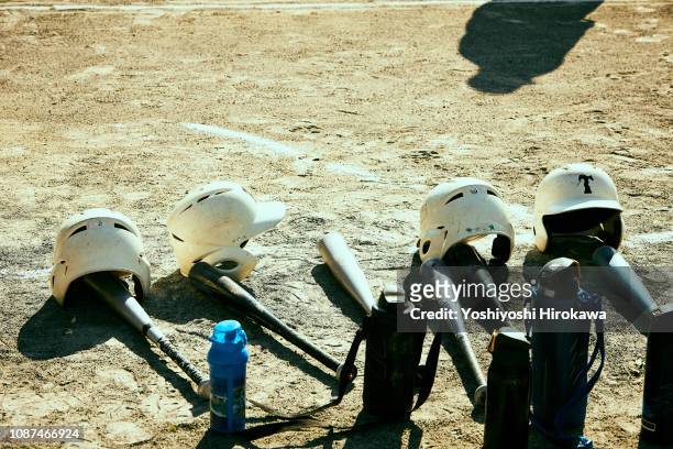 baseball bat,helmet and thermos bottle put on ground. - sportbegriff stock-fotos und bilder