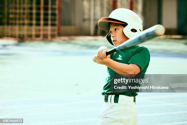 kids (8-9) swinging baseball bat at ball - batting sports activity - fotografias e filmes do acervo