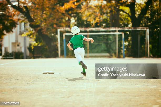 base runner running between bases in baseball game - batting sports activity - fotografias e filmes do acervo