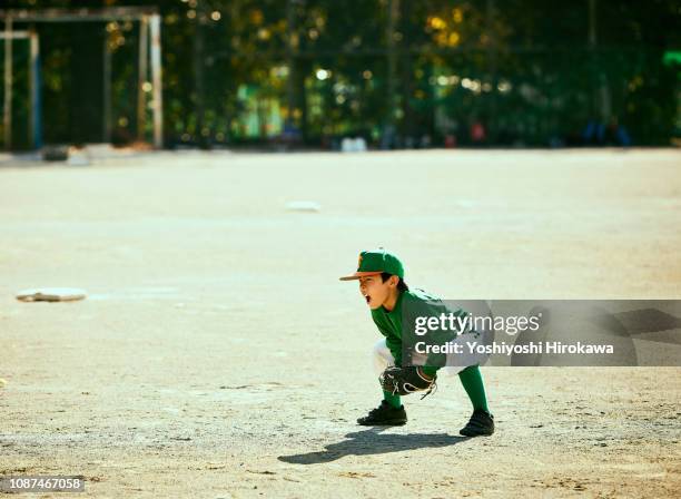 young baseball boy（6-7） standing in infield, wide view - 野球場　日本 ストックフォトと画像