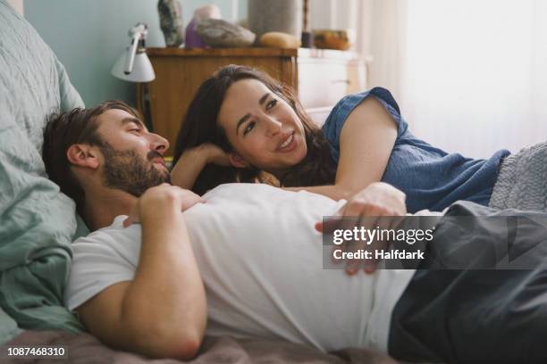 couple relaxing and talking on bed - couples in bed stock pictures, royalty-free photos & images