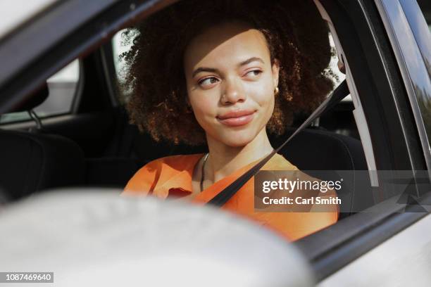 confident young woman driving car - indie smith stock pictures, royalty-free photos & images