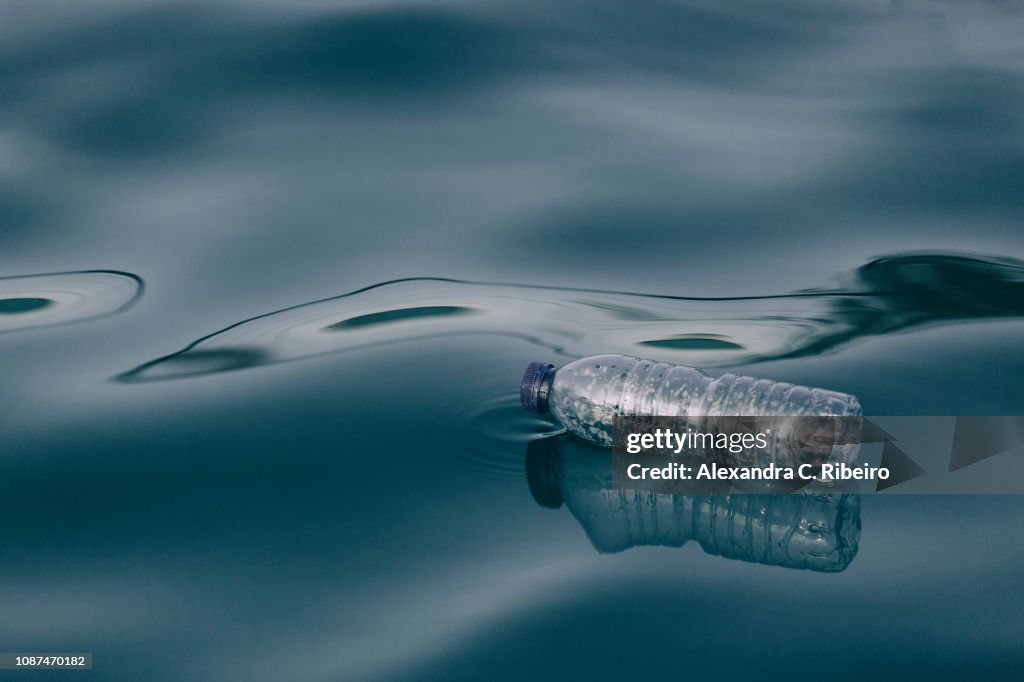 Plastic water bottle floating on water surface