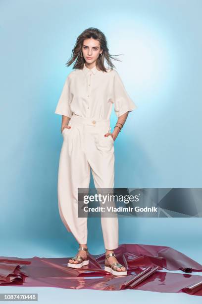 portrait of female fashion model posing against blue background - model full body stock-fotos und bilder