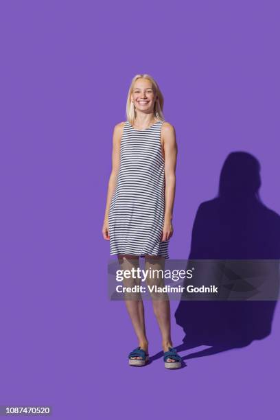 portrait smiling woman in striped dress against purple background - striped dress - fotografias e filmes do acervo