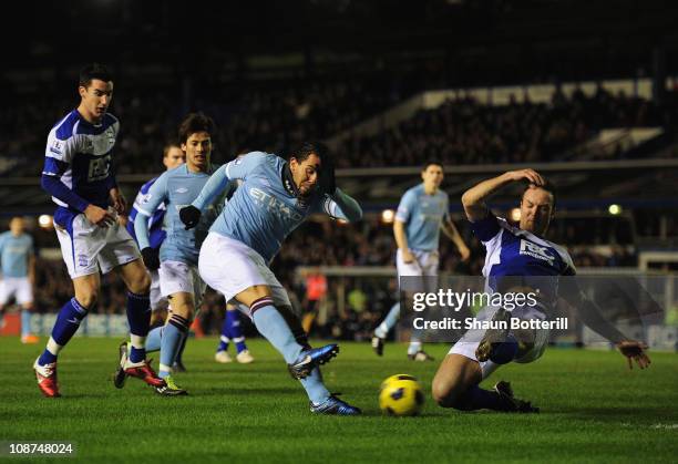 Carlos Tevez of Manchester City shoots past Martin Jiranek of Birmingham City to score during the Barclays Premier League match between Birmingham...