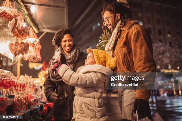 familia en compras navideñas - mercado navideño fotografías e imágenes de stock