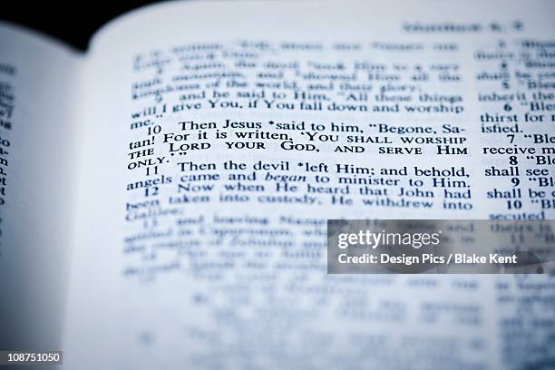 the bible open to matthew 4:10 where jesus is tempted in the wilderness - white jesus stock pictures, royalty-free photos & images