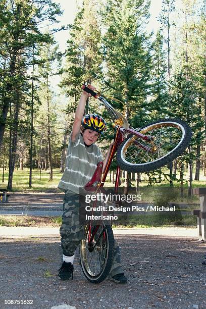 a boy plays with his bike in a campground - acrobazia foto e immagini stock