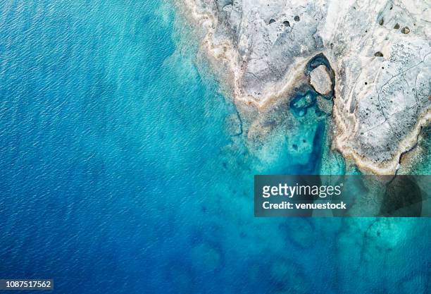 luchtfoto van de zee en rots - blue bay stockfoto's en -beelden