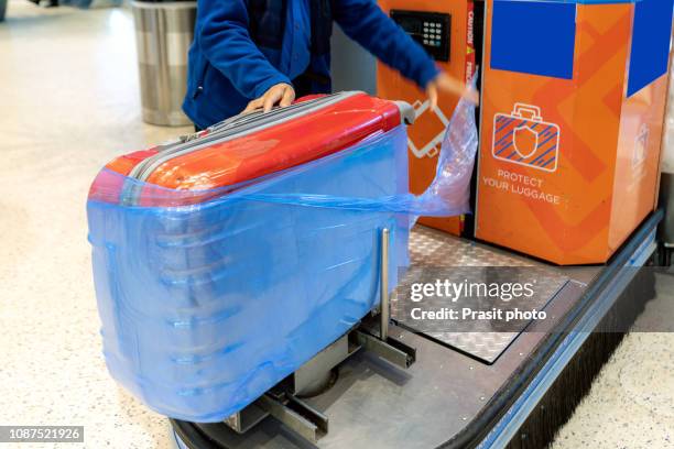 luggage wrap machine service at the airport - kado inpakken stockfoto's en -beelden