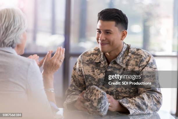 young male in uniform smiles at counselor - war veteran stock pictures, royalty-free photos & images