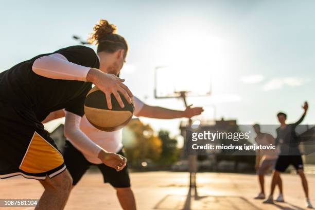 young man spelen goede verdediging - street basketball stockfoto's en -beelden