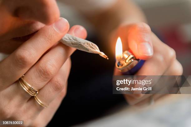 woman lighting marijuana joint - smoking joint stock pictures, royalty-free photos & images