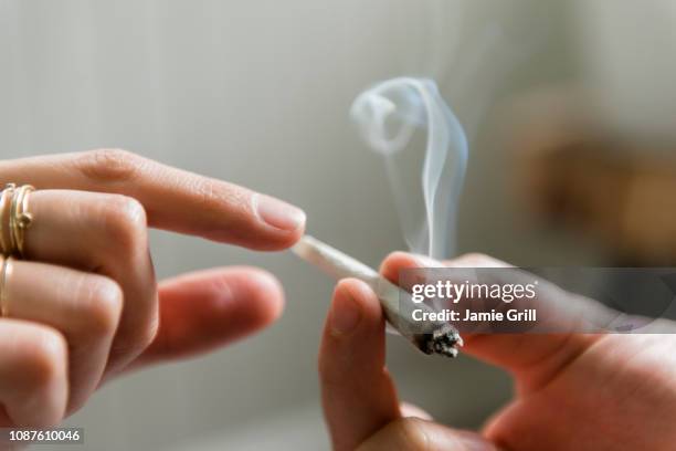 hands of man and woman passing marijuana joint - weed ストックフォトと画像