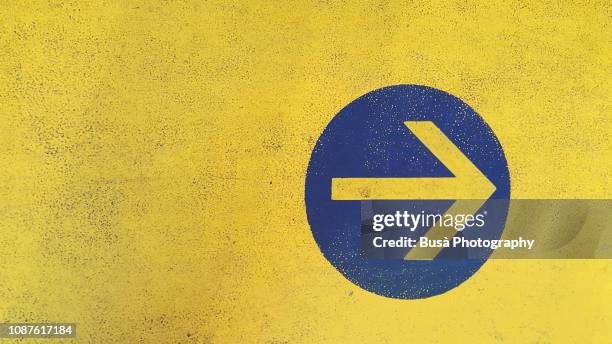 arrow symbol painted on asphalt in parking garage - yellow wall stock pictures, royalty-free photos & images