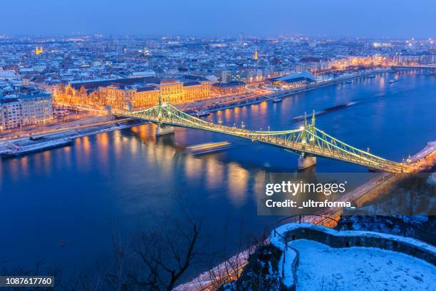 illuminated cityscape of budapest with snowy winter landscape at dusk - budapest winter stock pictures, royalty-free photos & images