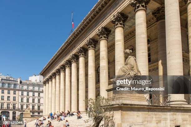 menschen sitzen auf den stufen vor dem gebäude der bourse du paris, bekannt als palais brongniart, zur stadt paris, frankreich. - börse von paris stock-fotos und bilder