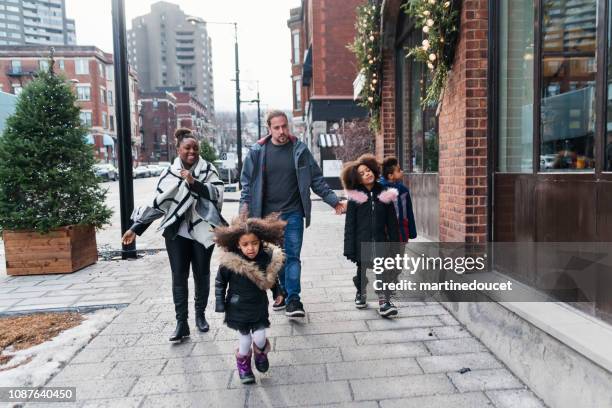 gemengd ras familie winkelen op stad straat in de winter. - montreal city stockfoto's en -beelden