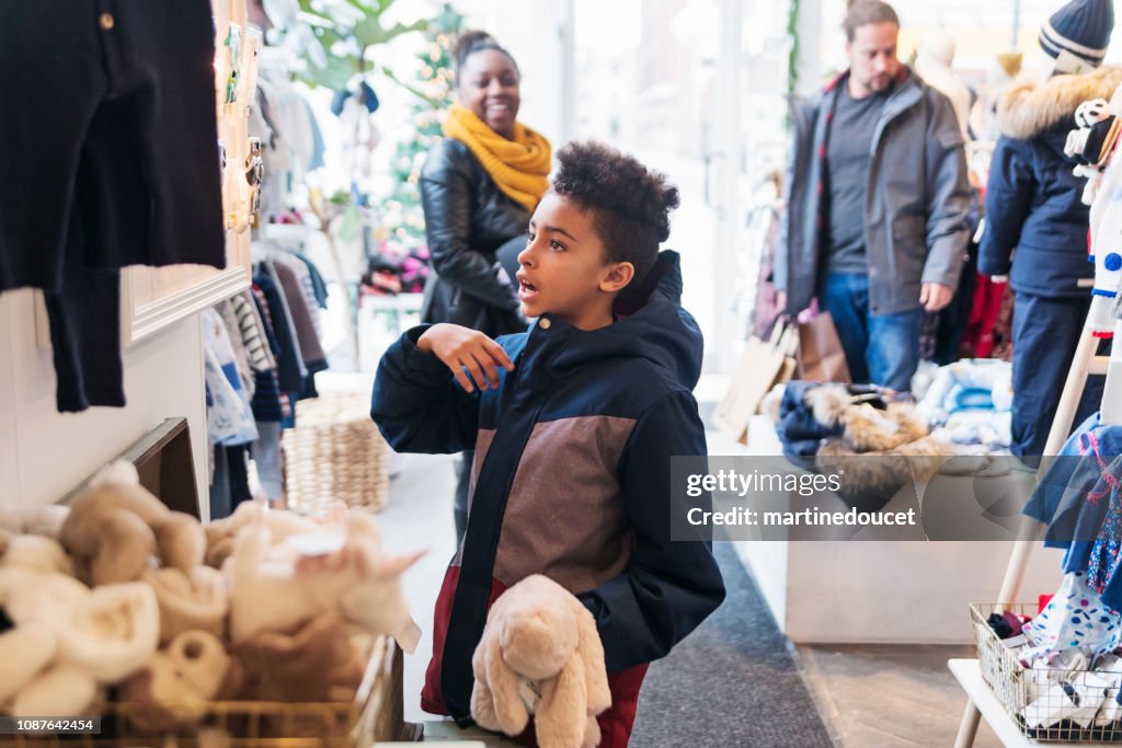 Mixed-race family shopping in children store in winter.
