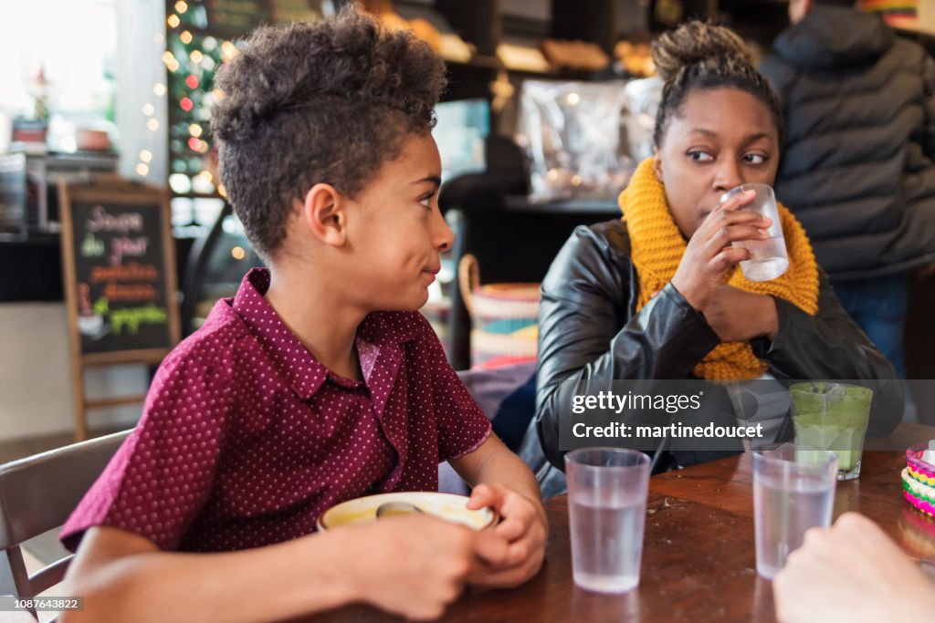 Mixed-race family eating in restaurant in winter.