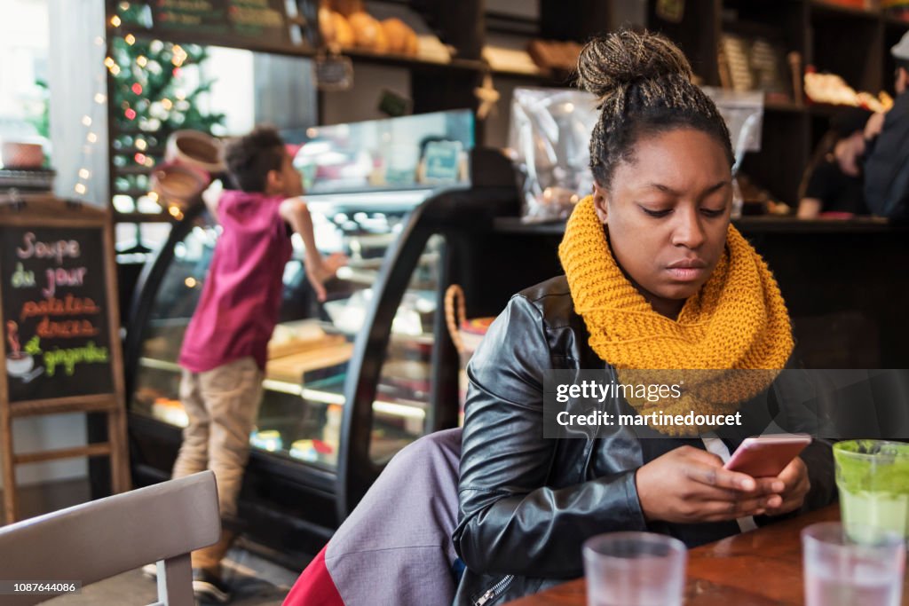 Mixed-race family eating in restaurant in winter.