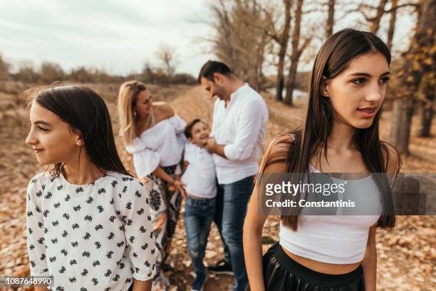 jealousy in the family. adventure in autumn leaves at park - sibling jealousy stock pictures, royalty-free photos & images