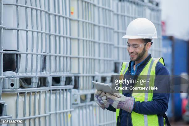 engineer checks shipment of chemicals at oil and gas industry pipeline job site - chemical imagens e fotografias de stock